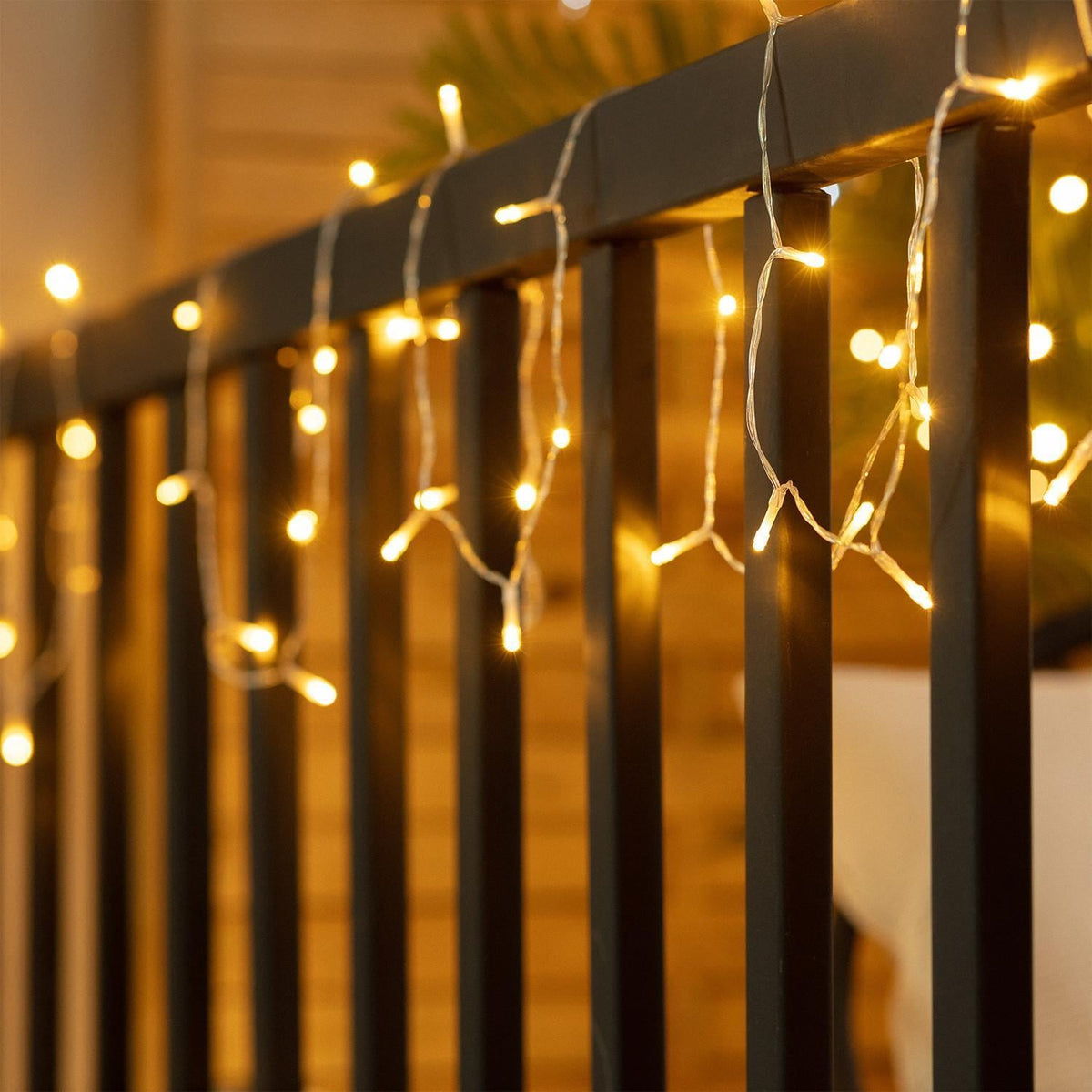 Guirnalda solar LED BRISA encendida para decorar una barandilla exterior